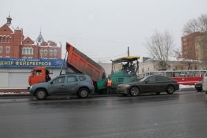 Омские дорожники продолжают асфальтировать улицы по колено в снегу