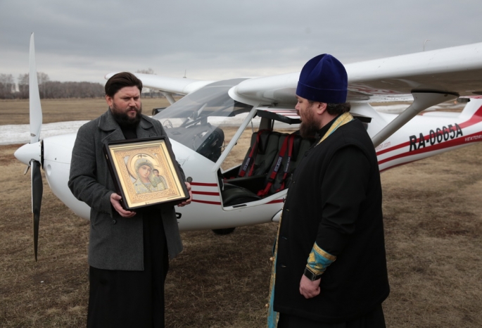 Священник с иконой облетел Омск на самолете в защиту от коронавируса